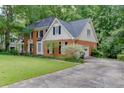 Traditional brick home with an attached garage and a well-maintained lawn at 711 Belgrave Ln, Tucker, GA 30084