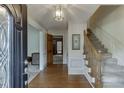 Inviting foyer with hardwood floors, a staircase, and decorative lighting at 711 Belgrave Ln, Tucker, GA 30084