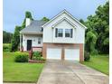 Two-story home boasting an attached two car garage, a well-maintained yard, and a charming front porch at 102 Ashbury Dr, Villa Rica, GA 30180