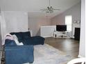 Spacious living room with a comfortable blue sectional couch, neutral walls, and wood-look floors at 102 Ashbury Dr, Villa Rica, GA 30180