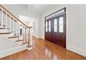 Elegant foyer with hardwood floors, a staircase, and a front door with decorative glass panels at 3134 Hudson Pond Ln, Marietta, GA 30062