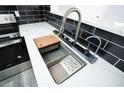 Modern kitchen sink with sleek faucet, cutting board, and white countertops at 3570 Briar Dr, Lithia Springs, GA 30122