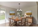 Elegant dining room with hardwood floors, modern lighting, and a window view at 250 Meadow View Dr, Grayson, GA 30017