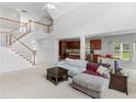 Open-concept living space featuring a staircase, kitchen, and natural light at 1613 Brolington Ct, Conyers, GA 30013