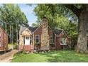 Lovely brick home with stone chimney, surrounded by lush trees and a green front yard at 311 Glendale Ave, Decatur, GA 30030