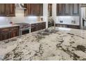 Expansive granite island featuring a double sink, stainless steel appliances, and custom cabinetry at 3663 Brookhaven Manor Crossing Ne, Atlanta, GA 30319