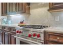 Gourmet kitchen with stainless steel Wolf range, custom cabinets, tiled backsplash, and granite counters at 3663 Brookhaven Manor Crossing Ne, Atlanta, GA 30319