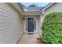 Welcoming front entrance with a classic black door, sidelights, and manicured bushes at 949 Harbins Pass Dr, Dacula, GA 30019