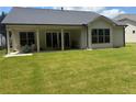 Backyard with large grassy area, a covered patio with pillars, and sliding glass doors to inside at 313 Sobeck Way, Canton, GA 30115