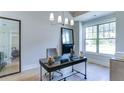Bright office space featuring a large window, modern chandelier, and stylish decor with a large framed mirror at 313 Sobeck Way, Canton, GA 30115