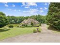 Beautiful home with a well-maintained lawn, mature trees, pond, and long driveway leading to the residence at 317 Red Gate Overlook, Canton, GA 30115