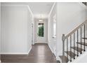 Bright entryway featuring wood-look flooring, a staircase with modern black railings and large windowed front door at 6934 Melody Ridge Rd, Buford, GA 30518