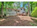Home exterior with deck and backyard featuring vibrant green trees at 5215 Mainstreet Park Dr, Stone Mountain, GA 30088