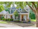 Charming two-story home with manicured landscaping, a brick facade, and a welcoming front porch at 3900 Baluster Ct, Suwanee, GA 30024