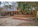 Cozy brick home featuring a covered porch, black shutters, and mature landscaping at 4225 Parkridge Dr, Powder Springs, GA 30127