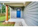 Close-up of front door featuring a blue-painted door, a small porch, and decorative white stones at 597 Woodcrest Manor Dr, Stone Mountain, GA 30083