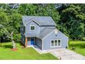 A charming two-story home showcases a blue exterior with a well-maintained yard, complemented by lush surrounding trees at 597 Woodcrest Manor Dr, Stone Mountain, GA 30083