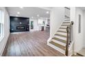 Bright, open-concept living space with hardwood floors, a fireplace, and a view of the kitchen and stairs at 597 Woodcrest Manor Dr, Stone Mountain, GA 30083