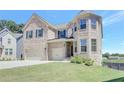 Charming two-story brick home with a well-kept lawn, showcasing its classic design at 932 Melville Dr, Stockbridge, GA 30281
