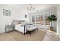 Serene bedroom with natural light, a decorative rug, and views of the surrounding trees at 125 Maison Court, Roswell, GA 30076