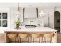Bright kitchen featuring a large island with seating, modern appliances, and designer pendant lighting at 125 Maison Court, Roswell, GA 30076