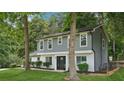 Charming home featuring a manicured lawn, gray siding, white brick and a striking black front door at 2079 Wellborn Rd, Lithonia, GA 30058