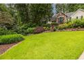 Well-manicured front lawn with mature trees and shrubbery, creating a park-like setting at 3300 Pierce St, College Park, GA 30337