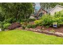 Landscaped front yard with vibrant flowers, manicured bushes, and a decorative stone border at 3300 Pierce St, College Park, GA 30337