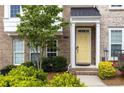 Close up of brick townhome entrance with yellow door, green landscaping, and charming details at 1995 Bryant Park Ln, Decatur, GA 30033