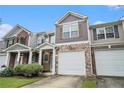 Charming townhome with stone accents, covered entrance, and an attached garage on a sunny day at 2731 Pierce Brennen Ct, Lawrenceville, GA 30043