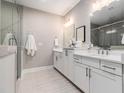 Stylish bathroom with double sinks, white cabinets, quartz countertops, and a tiled shower at 671 Brennan Dr, Decatur, GA 30033