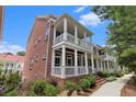 Stately brick townhome with inviting white-columned porches on two levels, offering classic Southern charm at 671 Brennan Dr, Decatur, GA 30033