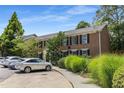 Well-maintained brick condominium exterior, showcasing lush greenery, black shutters and ample parking spaces at 1101 Collier Nw Rd # P2, Atlanta, GA 30318