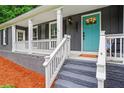 Inviting front porch with a blue door, white railings, and stylish exterior lighting at 261 Lamplighter Se Ln, Marietta, GA 30067