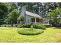 Landscaped yard featuring a gray home with a chimney and a quaint, white picket fence at 3754 Wyntuck Nw Cir, Kennesaw, GA 30152
