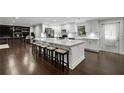 Spacious open kitchen with white cabinetry, a large island, and dark wood floors at 3844 Sw Saddle Ridge Dr, Snellville, GA 30039