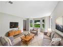 Bright living room featuring large windows, modern furniture, and neutral paint at 5159 Round Table Dr, Ellenwood, GA 30294