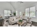 Bright living room with vaulted ceilings, large windows, and cozy, neutral-toned furniture at 658 Mcgruder Ne St, Atlanta, GA 30312