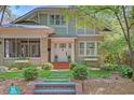 Charming two-story home with a welcoming front porch, brick pathway, mature trees, and manicured landscaping at 15 Northwood Ne Ave, Atlanta, GA 30309