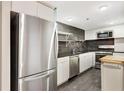 Bright kitchen with stainless refrigerator, sleek cabinets, black countertops, and open shelving at 1501 Clairmont Rd # 1522, Decatur, GA 30033