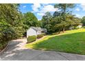 View of the exterior of a well-maintained house with a long driveway and lush green lawn at 165 Lost Lake Trl, Villa Rica, GA 30180