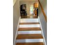 Staircase with wood treads and white risers leading to kitchen area at 120 Alfred Dr, Carrollton, GA 30116
