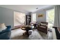 Comfortable living room with piano, plush seating, and bright windows at 4188 Kindlewood Ne Ct, Roswell, GA 30075