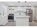 Modern kitchen featuring white cabinets, stainless steel appliances, and stylish pendant lighting at 2106 Singer Way, Lithonia, GA 30058