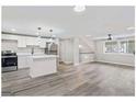 Open-concept kitchen featuring white cabinets and stainless steel appliances next to a living area at 2106 Singer Way, Lithonia, GA 30058