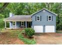 Inviting blue home with a covered front porch, two-car garage, and well-maintained landscaping at 4990 Turtle Rock Drive Dr, Marietta, GA 30066