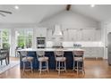Bright, open kitchen featuring a large navy island, white cabinetry, and stainless steel appliances at 4445 Pebble Rock Dr, Cumming, GA 30041