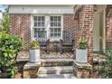 Charming front porch with rocking chairs, decorative planters, and a brick facade at 1718 Ridgewood Ne Dr, Atlanta, GA 30307