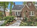 Inviting brick home featuring a cozy front porch with chairs and manicured greenery at 1718 Ridgewood Ne Dr, Atlanta, GA 30307