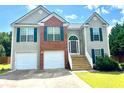 Traditional two-story home with two-car garage, brick facade, and inviting front entrance with stairs at 203 Galway Ln, Hampton, GA 30228